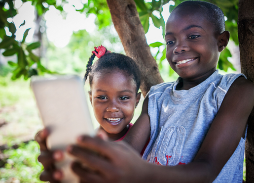 2 children in nature holding a smartphone 