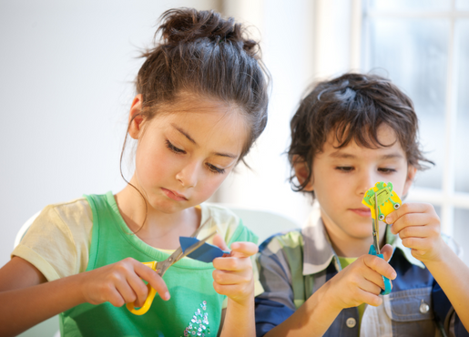 Two small children creating crafts. 