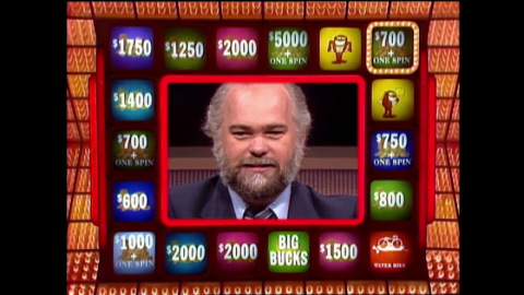 Man's head in the middle of a game show board of lights and prizes around him