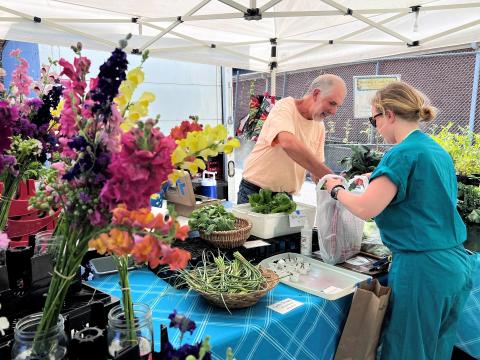  A vendor at the Northside Farmers Market sells vegetables. The market was one of the first in the state to accept SNAP benefits 11 years ago.