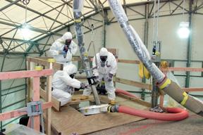 Workers at Fernald remove thorium-bearing waste from a silo in 2005. <br/>