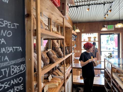  An Athens Bread Company employee packages up pastries for customers on a sunny afternoon.