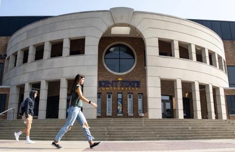 People walk past the Memorial Athletic and Convocation Center at Kent State University's main campus. The university recently announced it intends to cut spending by tens of millions of dollars over the next four years. That could result in cuts to academic programs and employee positions.