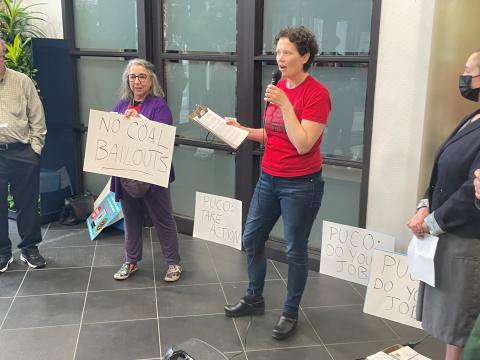 Molly McKenzie Nichols with the Ohio Sierra Club's Beyond Coal campaign speaks to activists gathered in the lobby of the building housing the Public Utilities Commission of Ohio. The group went to the PUCO meeting to deliver postcards to commissioners asking them to order utilities to stop collecting charges related to two coal-fired power plants.