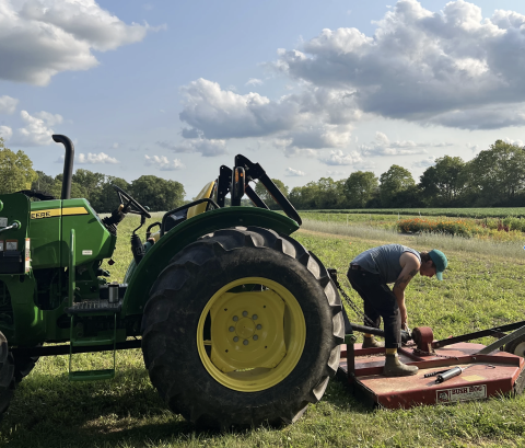 A farmer works on a tractor at Larissa Duprey's 12-acre farm in Yellow Springs.