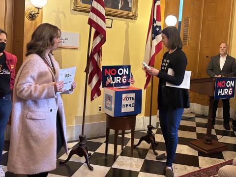 Opponents of resolution to make it harder to pass constitutional amendments in Ohio put ballots in ballot box as part of a demonstration at the Ohio Statehouse