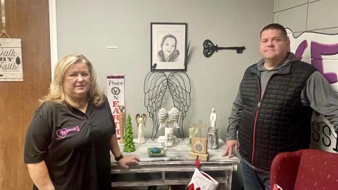 Brenda Ryan (left) and her son Jason Moore (right) stand next to a painting of Ryan's daughter, Sheena Moore. Ryan founded a nonprofit called Keys 2 Serenity after her daughter died of an opioid overdose in 2016.