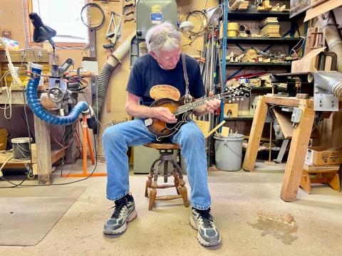 Don MacRostie plays one of the Red Diamond mandolins he made last year. He hand crafted the instrument in his workshop in Athens County.