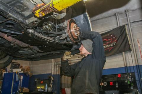 Chase Beckert of Columbus works on a car at Weber Road Auto Service in Columbus’ North Linden Neighborhood.