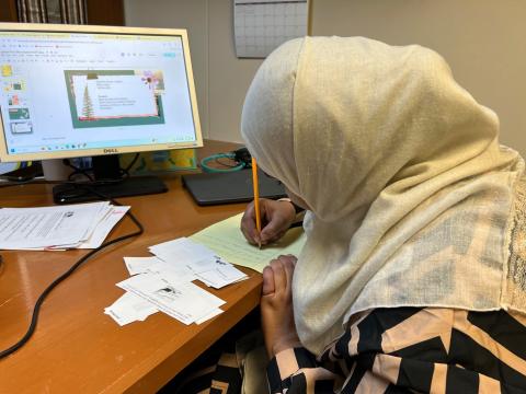 Tahani Mohamed reviews vocabulary words in a small classroom at Water for Ishmael. She's studying to become an office assistant, with hopes of someday working in the medical field.