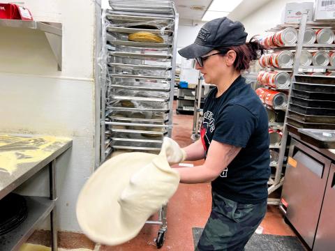 Pizza chef Brittany Saxton stretches dough in the kitchen of her restaurant, Six Hundred Downtown in Bellefontaine. Last year, she clinched her sixth world medal in fastest dough tossing at the World Pizza Games.