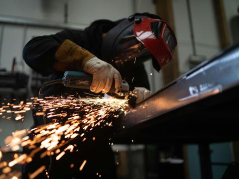 Sparks fly from a welding tool as a person in safety gear works. The state has invested money to aid Ohio high school students in getting hands on experience in fields like advanced manufacturing.