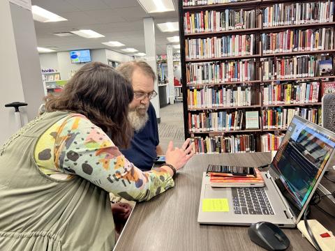 Chloe Gauthier shows Tom Reams how to delete apps of his smartphone at Ada Public Library.