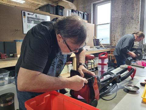 Volunteer tinkerer Don Hoffman works on a clogged vacuum. If he's able to get it working again, it will be sent on to someone who can use it.