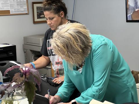 The local homeless coalition staff prints out paperwork at the Community Resource Center in Marietta in June.