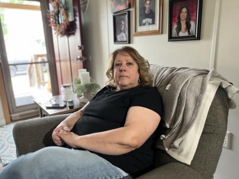 Volunteer firefighter Peg Dugan sits in her home across the street from the Tiltonsville Volunteer Fire Department. Her husband, Doug Dugan, was the chief of the department before he died on duty in 2021.
