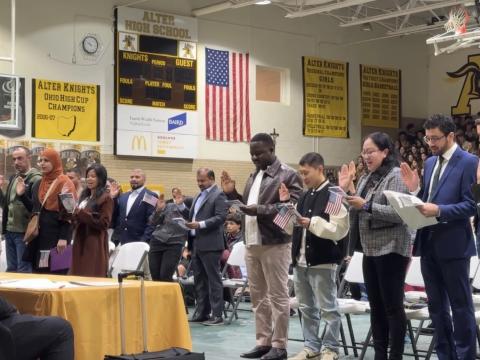 People holding their hand up while giving Oath of Allegiance, the final step to giving citizenship at a ceremony in Kettering on Feb. 12.<br>