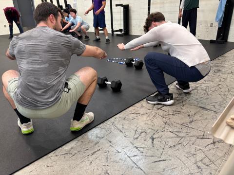 Coach Austin Haines shows correct form to a young participant of Expanding Horizons at the Circleville Juvenile Corrections Facility.