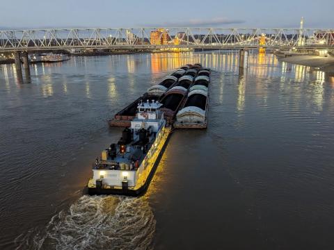 A boat pushes barges down the Ohio River between Cincinnati, Ohio, and Newport, Kentucky, in the early morning hours of February 24, 2023.