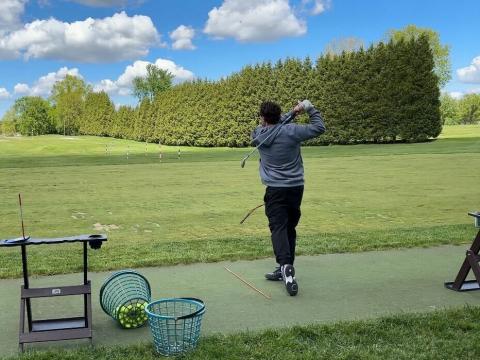 Gary Innes, a tennis professional, hits a golf ball at the driving range at the Portage Country Club on May 14, 2026.