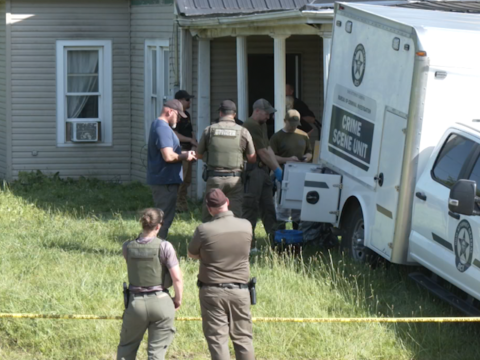 Law enforcement officers gather outside a home in Vinton County where four people were arrested Tuesday on charges of child endangerment.