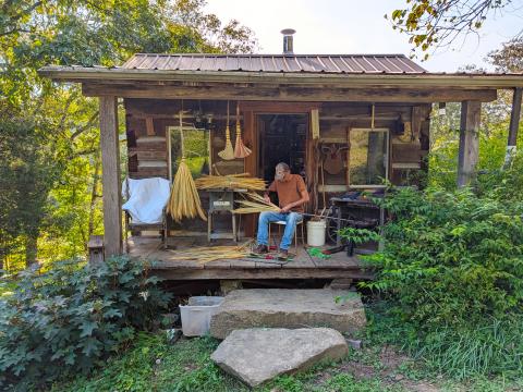 Curt Cable makes a broom on the porch of his workshop in Morgan County.